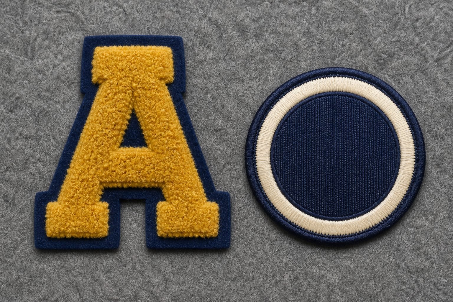 Plush gold chenille letter patch next to a flat embroidered crest